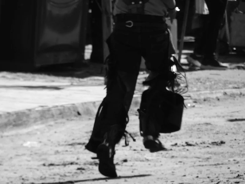 Fotografia em preto e branco, no formato horizontal, mostrando da cintura para baixo o corpo de uma pessoa em movimento.