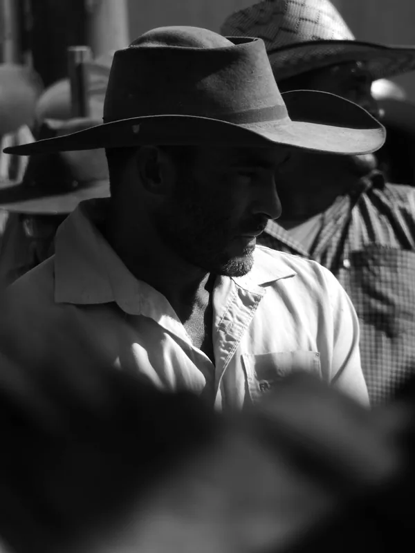 Fotografia em preto e branco, no formato vertical, mostrando o retrato de um carreiro usando chapéus de abas largas.